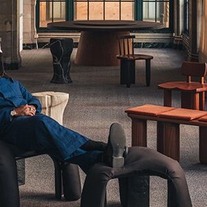 Designer Michael Bennett reclining with feet up on furniture he designed.